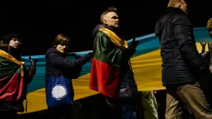 Žmonės su Lietuvos ir Ukrainos vėliavomis dalyvauja solidarumo eisenoje Vilniaus gatvėse.